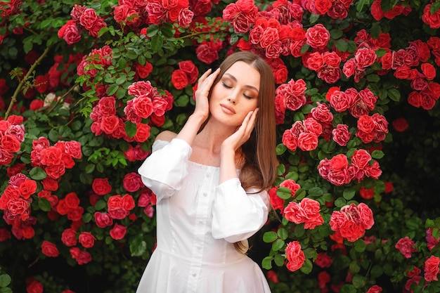 Una hermosa joven entre los arbustos en flor.