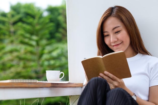 Una hermosa joven asiática escribiendo en un cuaderno al aire libre