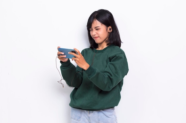 Hermosa joven asiática escuchando música y danza aislada de fondo blanco