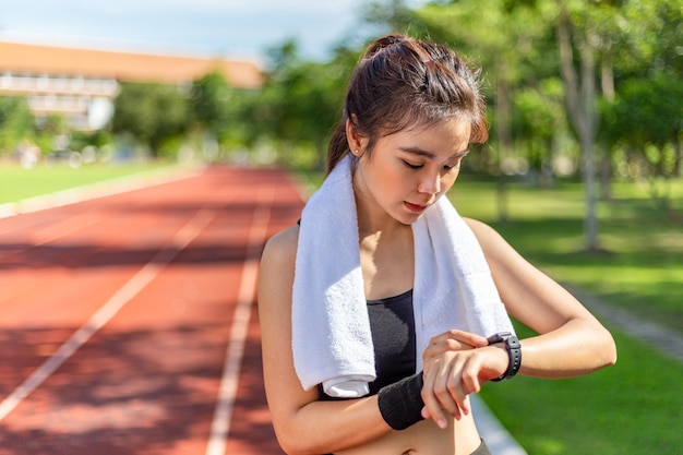 Hermosa joven asiática haciendo ejercicio por la mañana en una pista de atletismo