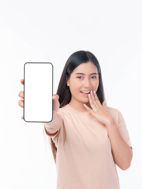 Foto hermosa joven asiática mostrando un gran teléfono inteligente con pantalla en blanco, pantalla blanca, espacio de copia vacío para banner publicitario aislado en fondo blanco, imagen simulada