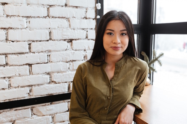 Hermosa joven asiática de pie en el café