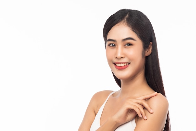 Hermosa joven asiática con piel limpia y fresca. Concepto de tratamiento facial, cosmetología, belleza y cuidado de la piel. Cara de belleza de niña aislada sobre fondo blanco