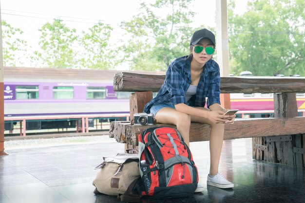 hermosa joven asiática que viaja sola en la estación de tren