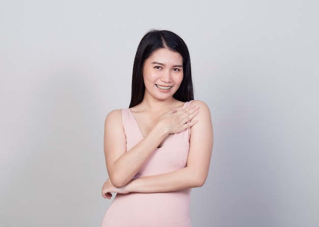 Hermosa joven asiática sonriente retrato una niña con vestido rosa de desgaste divertirse y feliz de positivo con éxito aislado sobre fondo blanco.