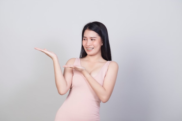 Hermosa joven asiática sonriente retrato una niña con vestido rosa de desgaste divertirse y feliz de positivo con éxito aislado sobre fondo blanco.