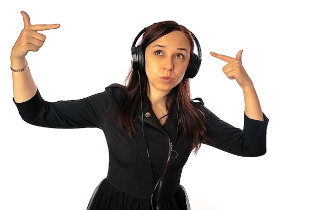 Una hermosa joven con auriculares baila aislada de fondo blanco El concepto del Día Internacional de la Música