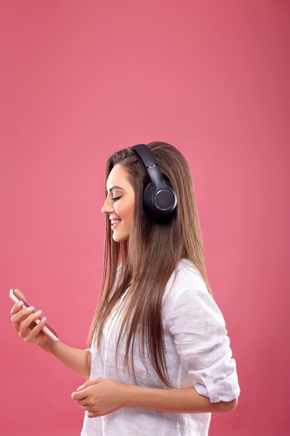 Hermosa joven con auriculares inalámbricos escuchando música Chica usa auriculares inalámbricos