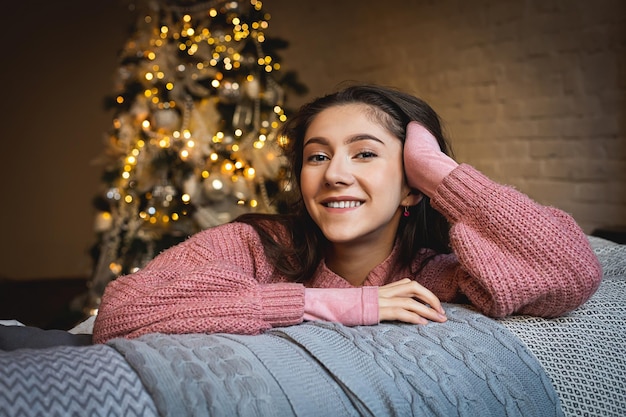 Hermosa joven en el backgrol niña en el fondo del interior de Navidad