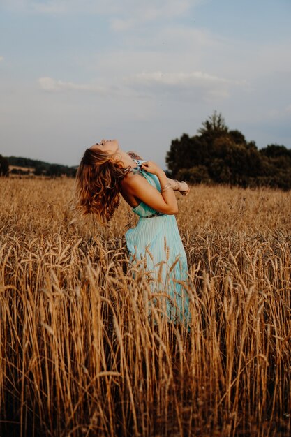 Hermosa joven bailando en el campo al atardecer