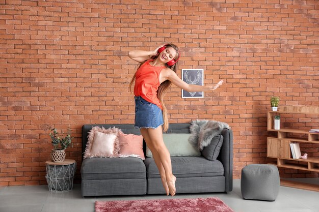 Hermosa joven bailando en casa