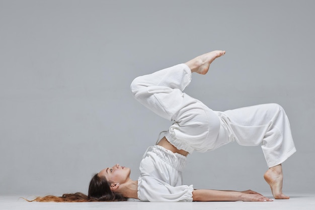 Hermosa joven bailarina moderna o bailarina de fitness sobre un fondo blanco aislado