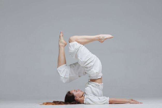 Hermosa joven bailarina moderna o bailarina de fitness sobre un fondo blanco aislado