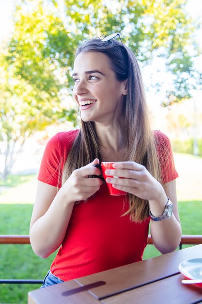 Foto hermosa joven bebiendo café al aire libre