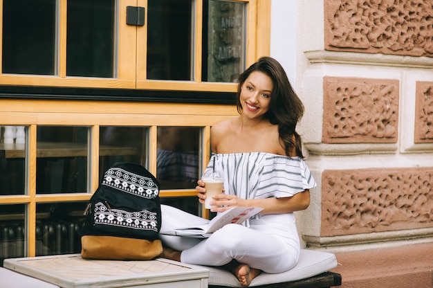 hermosa joven bebiendo café en la ciudad