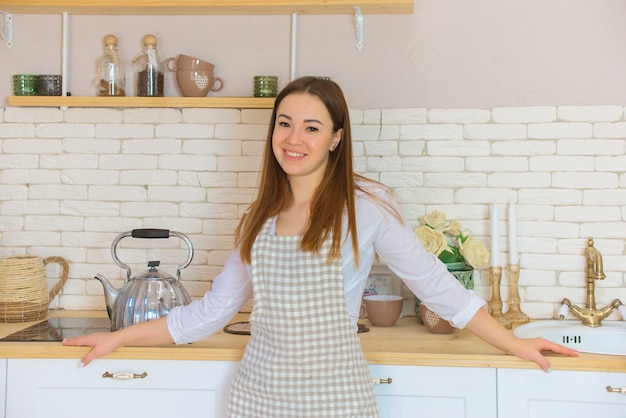 Hermosa joven bebiendo té en su cocina