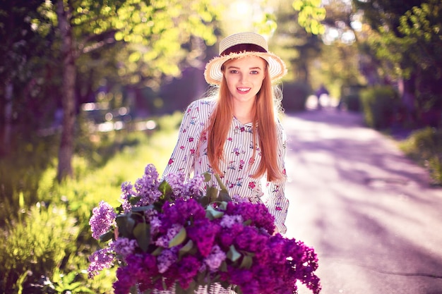 Hermosa joven con bicicleta vintage y flores