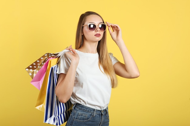 Foto hermosa joven con bolsas de papel para ir de compras