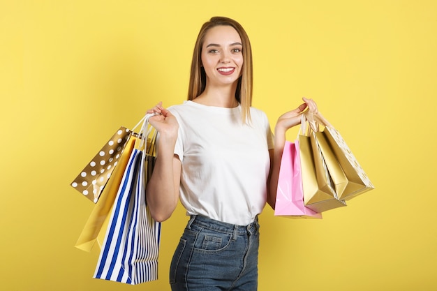 Hermosa joven con bolsas de papel para ir de compras