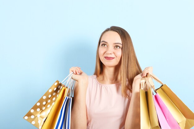 Hermosa joven con bolsas de papel para ir de compras