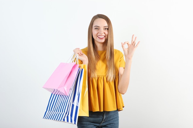 Hermosa joven con bolsas de papel para ir de compras