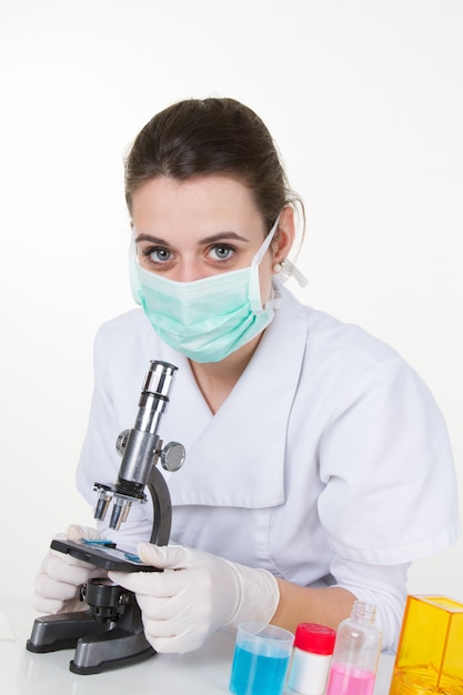 Hermosa joven bonita mujer científica haciendo experimentos en el laboratorio con un microscopio