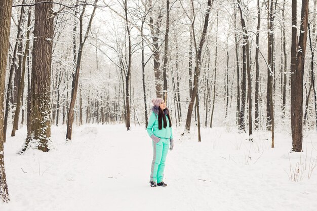 Hermosa joven en un bosque de invierno blanco.