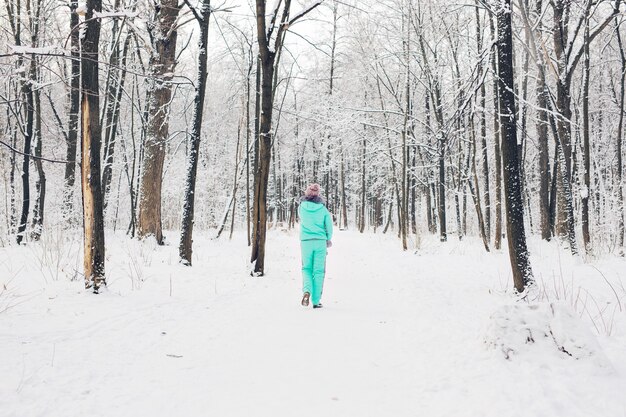 Hermosa joven en un bosque de invierno blanco.