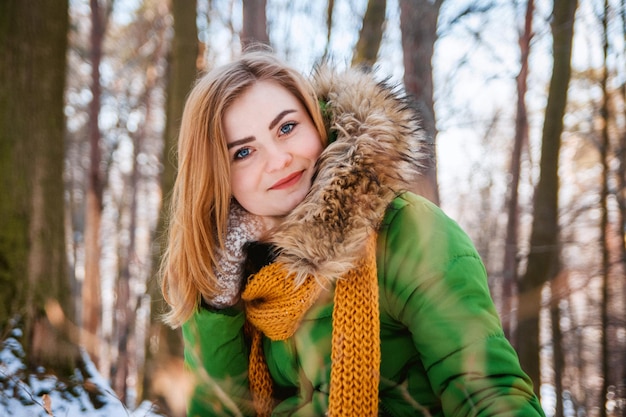 Hermosa joven en un bosque de invierno Retrato de invierno de mujeres vestidas con guantes y bufanda
