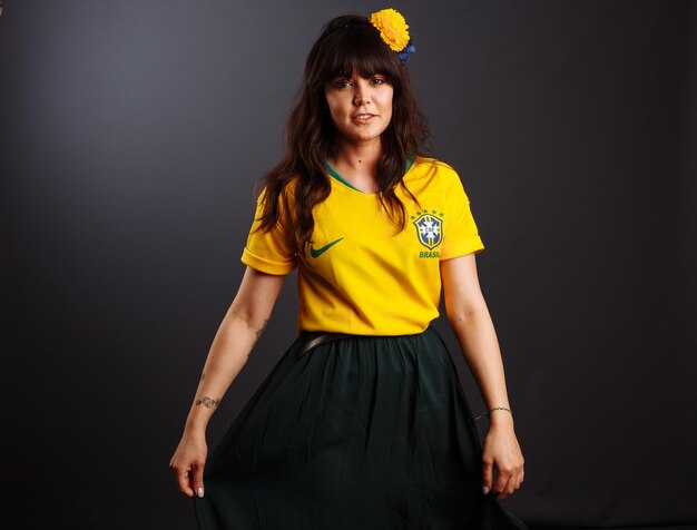 Hermosa joven brasileña con feliz mujer sonriente vistiendo la camiseta de fútbol de Brasil