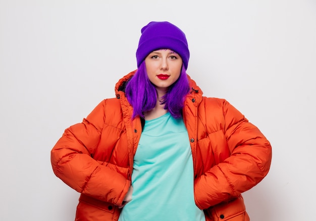 Hermosa joven con cabello morado y chaqueta naranja.