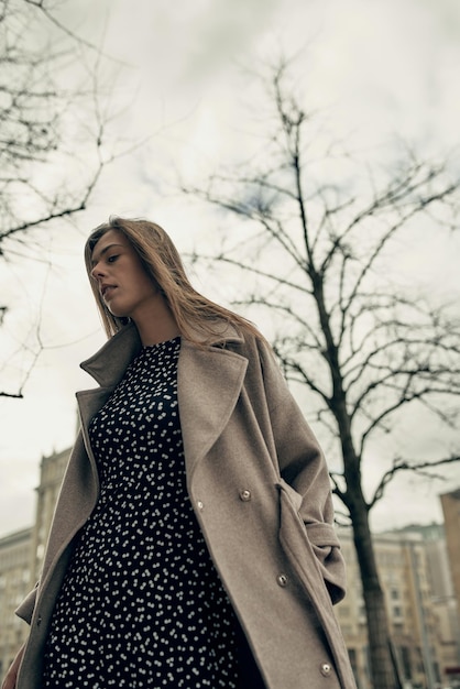 Una hermosa joven camina en la ciudad en otoño. Primavera en la ciudad. Belleza. nubes de tormenta.