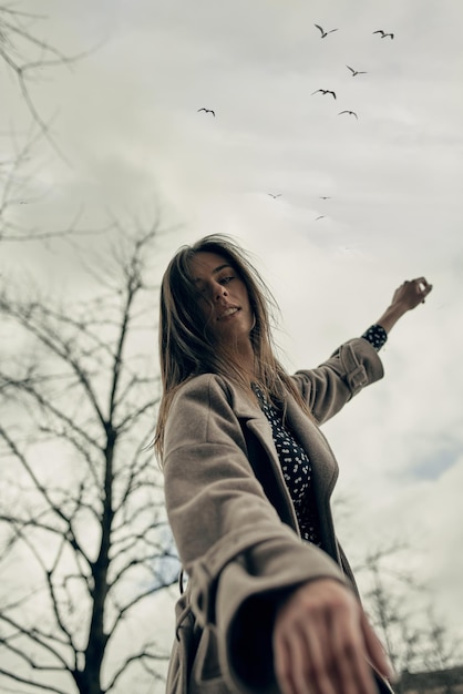 Una hermosa joven camina en la ciudad en otoño. Primavera en la ciudad. Belleza. nubes de tormenta.