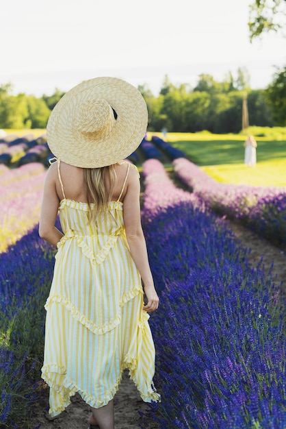 Hermosa joven en un campo lleno de flores de lavanda