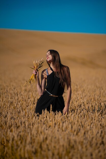 hermosa joven en campo de trigo dorado