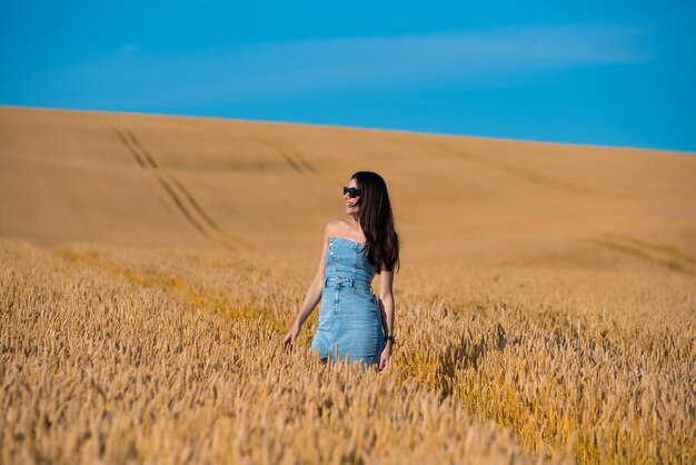 hermosa joven en campo de trigo dorado
