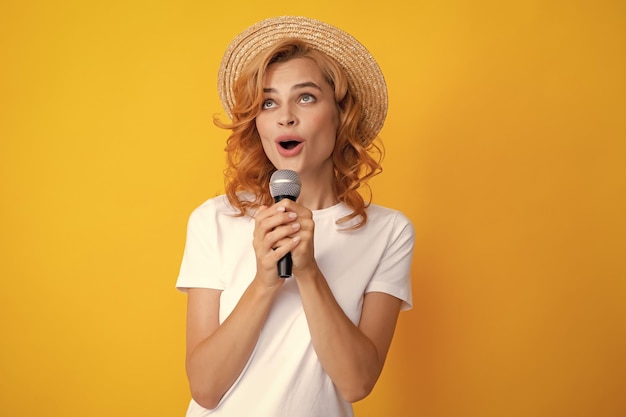 Hermosa joven cantando karaoke aislado en amarillo Chica cantando canción de la banda sonora en el micrófono
