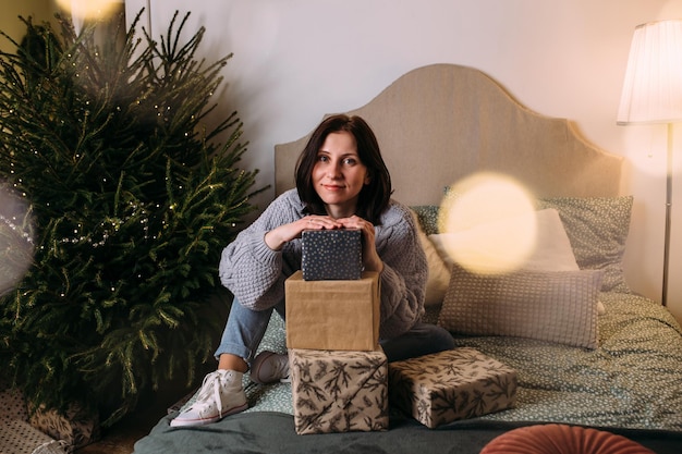 Hermosa joven en casa para navidad con regalos