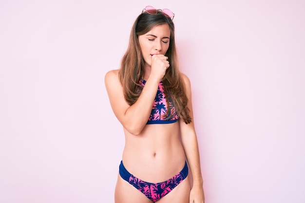 Foto hermosa joven caucásica con bikini y gafas de sol sintiéndose mal y tosiendo como síntoma de resfriado o bronquitis concepto de atención médica