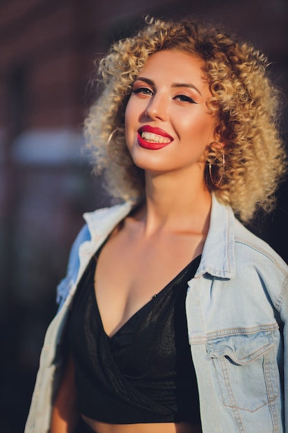 Hermosa joven caucásica con pelo rizado al aire libre