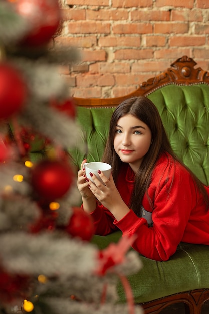 Hermosa joven cerca del árbol de Navidad