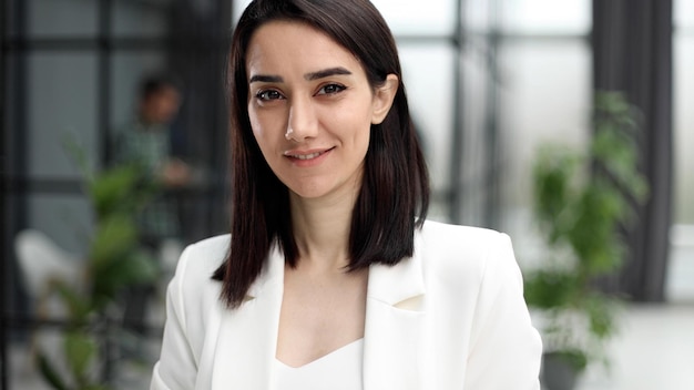 Hermosa joven con chaqueta blanca sonriendo a la cámara