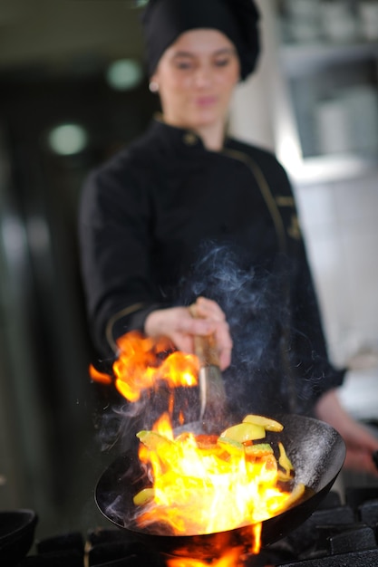 hermosa joven chef mujer preparar y decorar comida sabrosa en la cocina