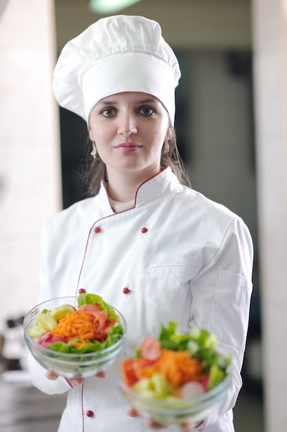 hermosa joven chef mujer preparar y decorar comida sabrosa en la cocina