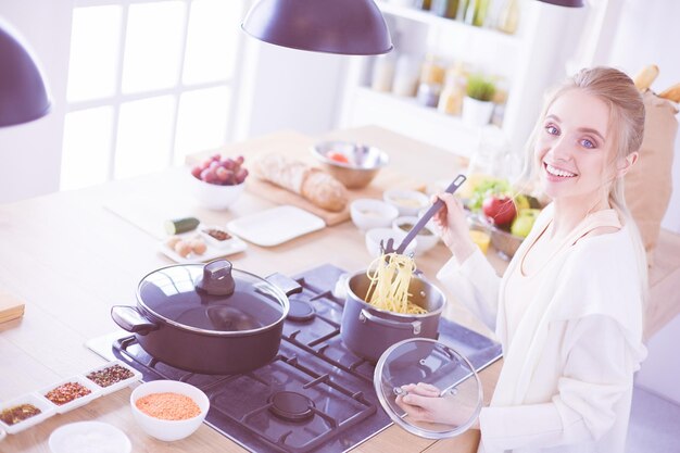 Foto hermosa joven cocinando en la cocina de casa