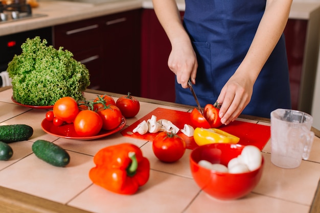 Hermosa joven cocinando comida en casa