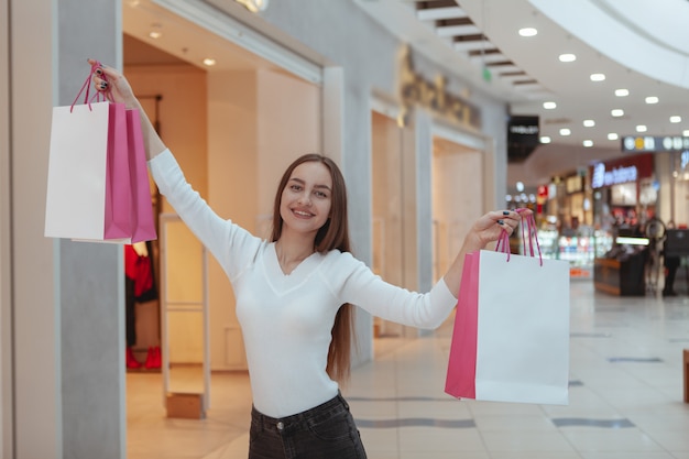 Hermosa joven de compras en el centro comercial local