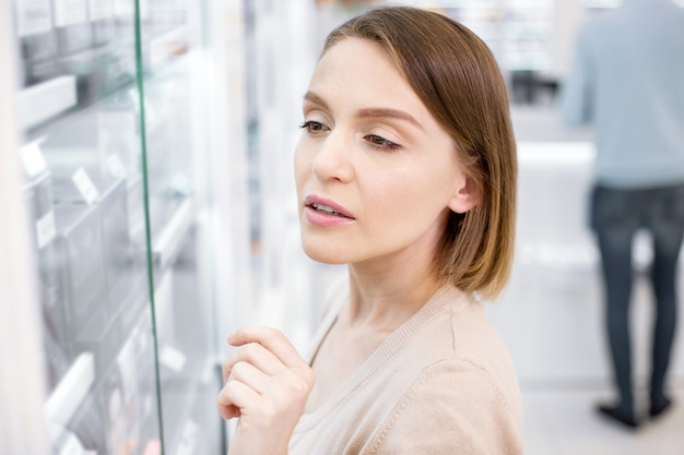 Hermosa joven de compras en una farmacia