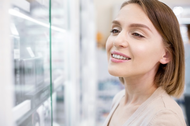 Hermosa joven de compras en una farmacia