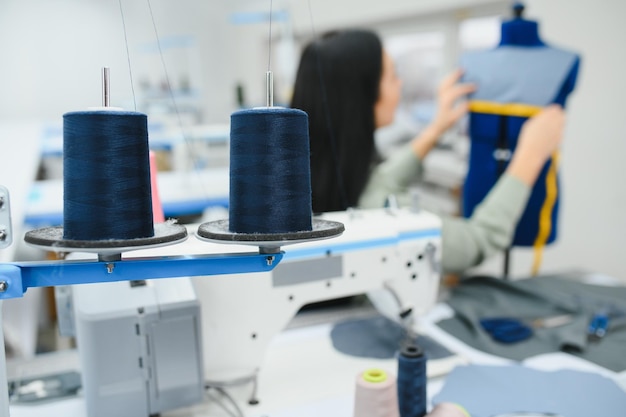 Foto hermosa joven cosiendo ropa con máquina de coser